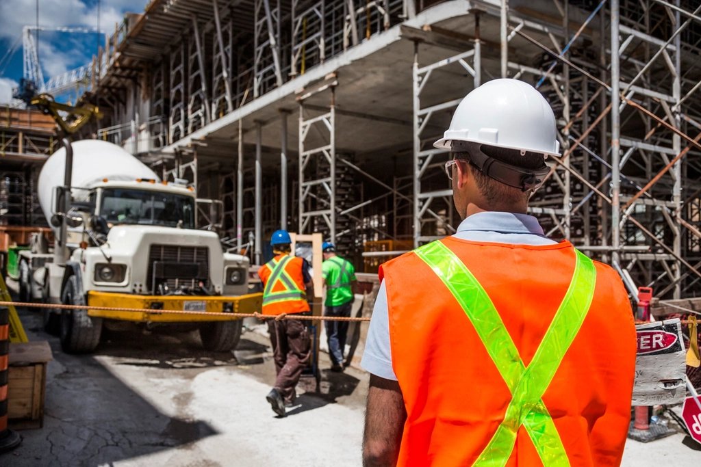 Un operaio con casco e gilet ad alta visibilità in un cantiere edile
